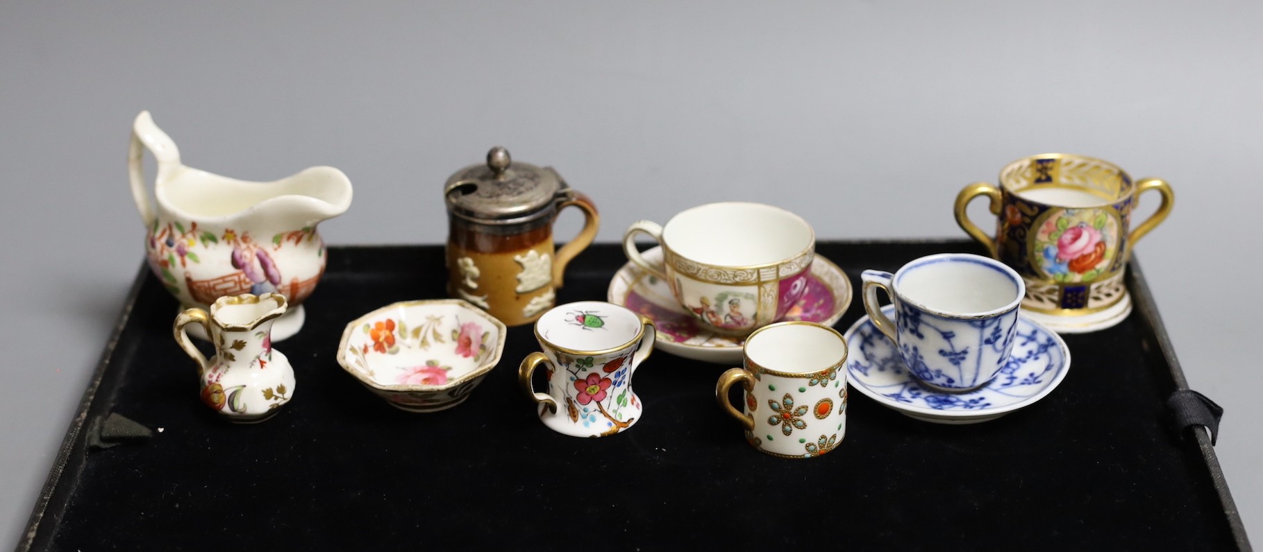 Miniatures: A Spode type Hydra jug and basin painted with flowers, a Crown Staffordshire two handled mug with flowers on a gilded blue ground, two continental cups and saucer one with Watteauesque scenes, the other in bl